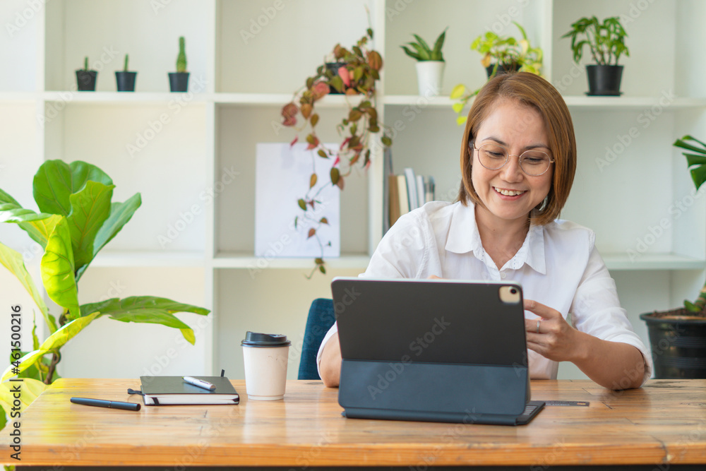 Serious focused middle aged female accountant in eyewear working from home providing outsource bookk