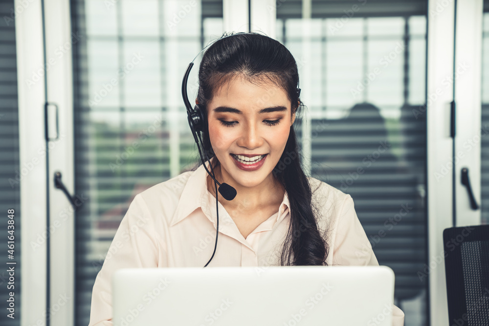 Businesswoman wearing headset working actively in office . Call center, telemarketing, customer supp