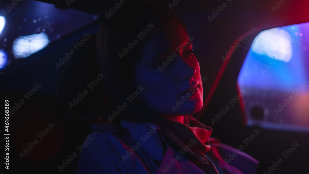 Close Up Portrait of a Female Commuting Home in a Backseat of a Taxi at Night. Beautiful Woman Passe