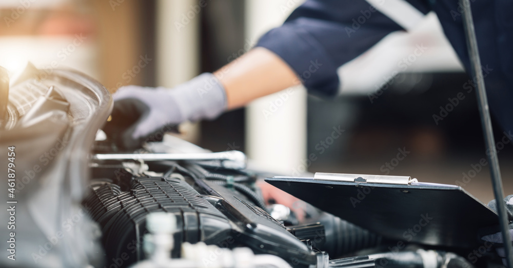 Car service, repair, maintenance concept,auto mechanic man or Smith writing to the clipboard at work