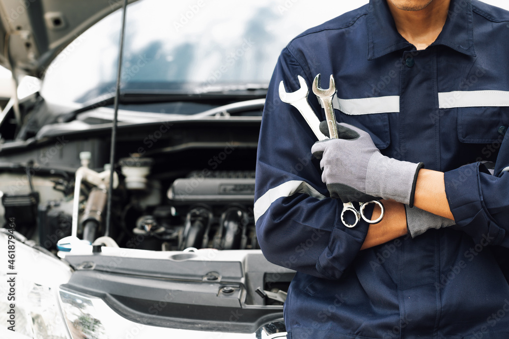 Hand of car mechanic with wrench. Auto repair garage. mechanic works on the engine of the car in the