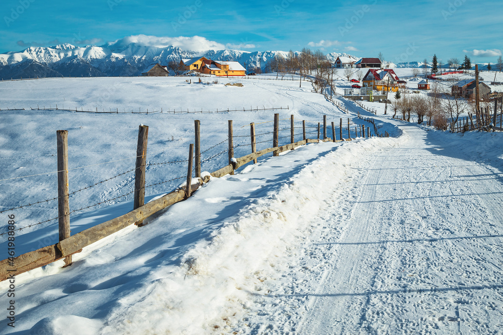 深雪景观和以山脉为背景的Pestera村庄