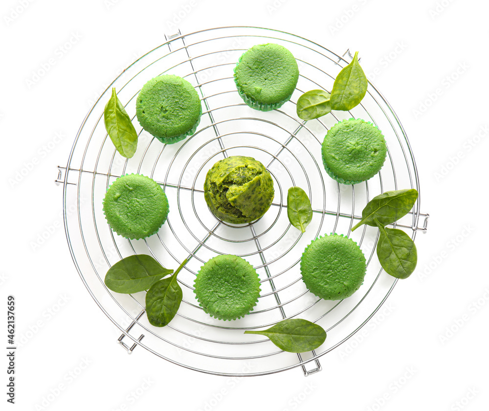 Grid with tasty spinach muffins on white background