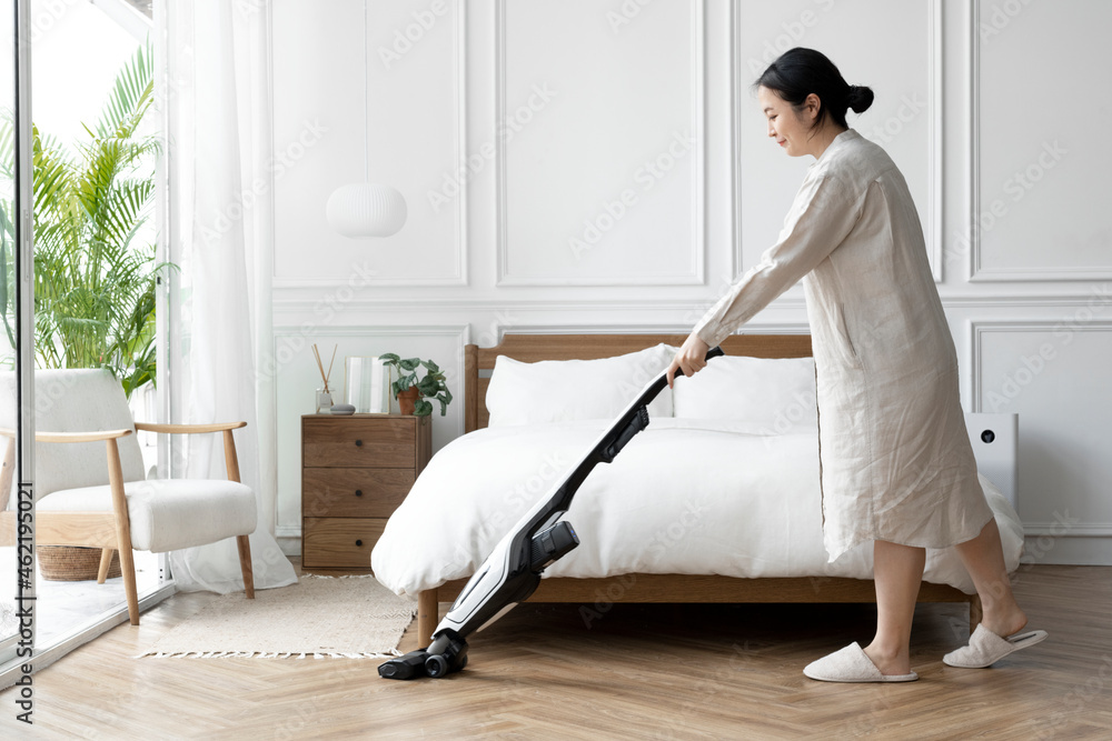 Japanese woman vacuuming her bedroom