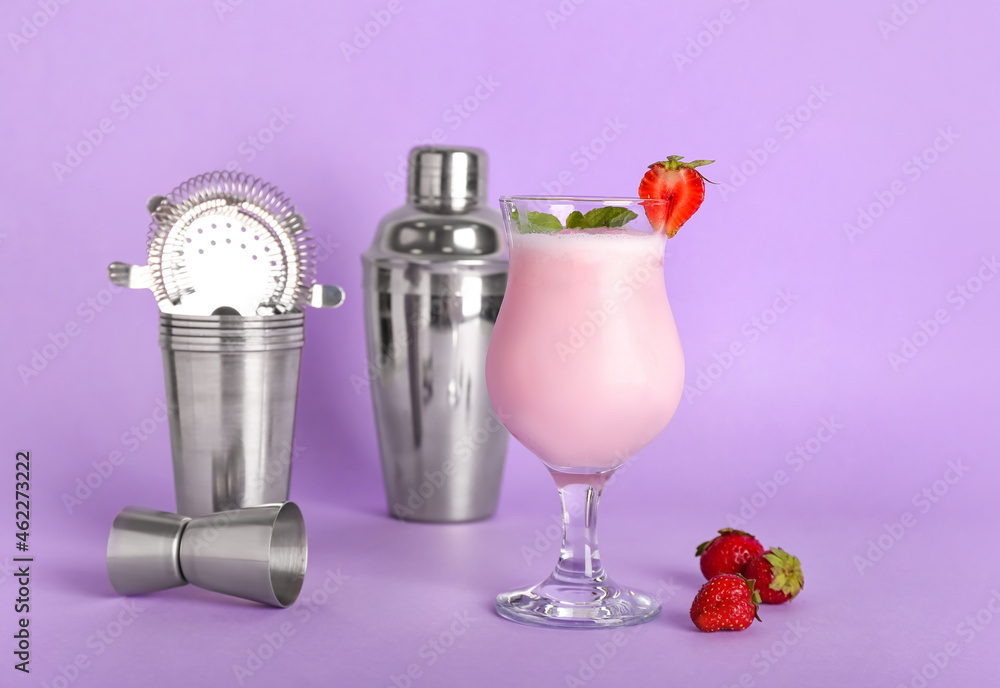 Glass of strawberry Pina Colada cocktail and shaker on color background