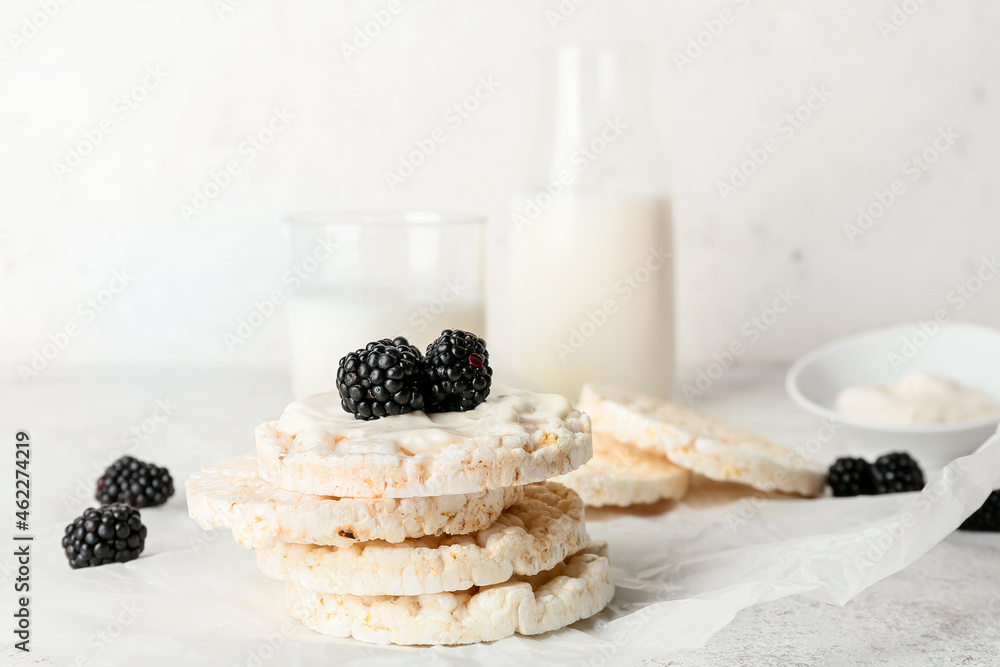 Puffed rice crackers and blackberry on light background