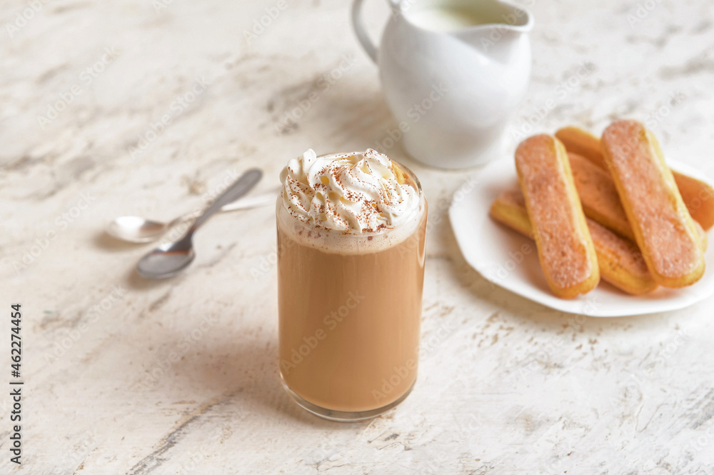 Glass of tasty Tiramisu Latte on light background