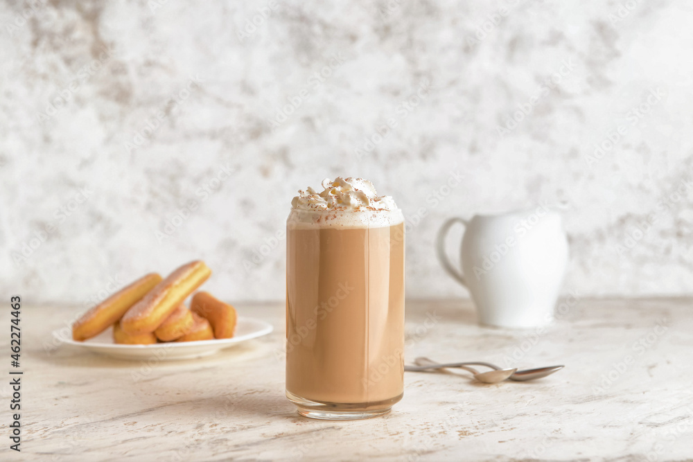 Glass of tasty Tiramisu Latte on light background