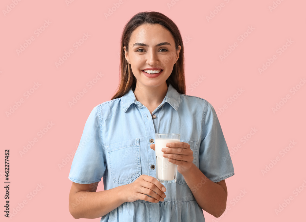 Young woman with glass of fresh milk on color background