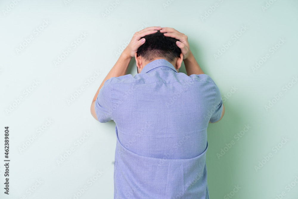 Young Asian businessman posing on green background