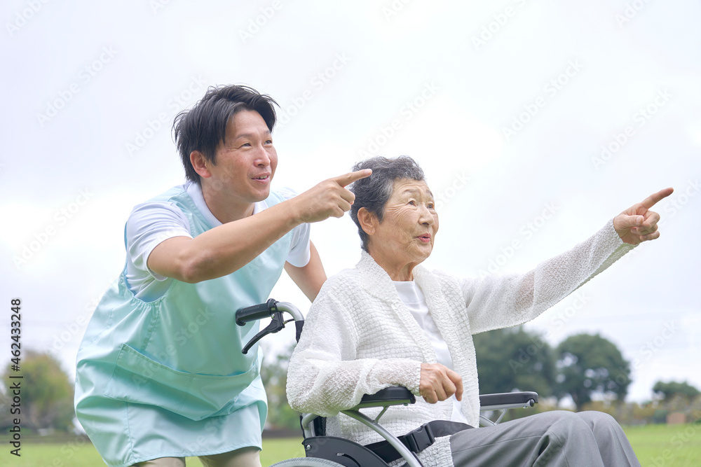 介護士と車椅子に乗る高齢者