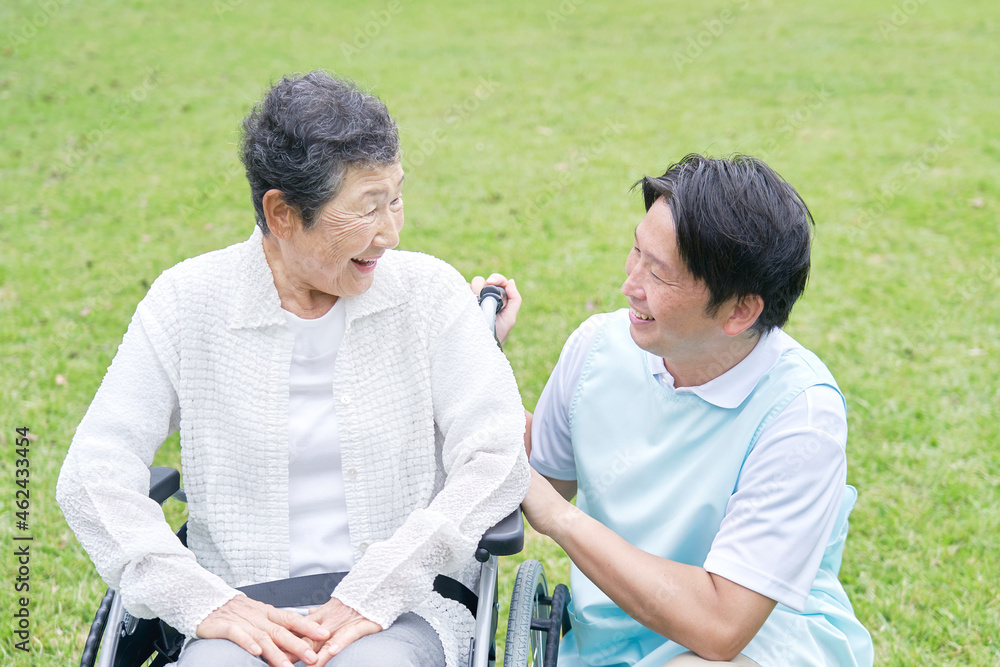 介護士と車椅子に乗る高齢者