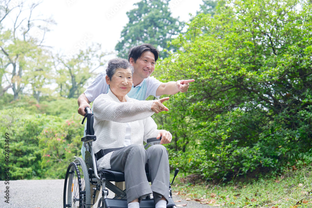 介護士と車椅子に乗る高齢者