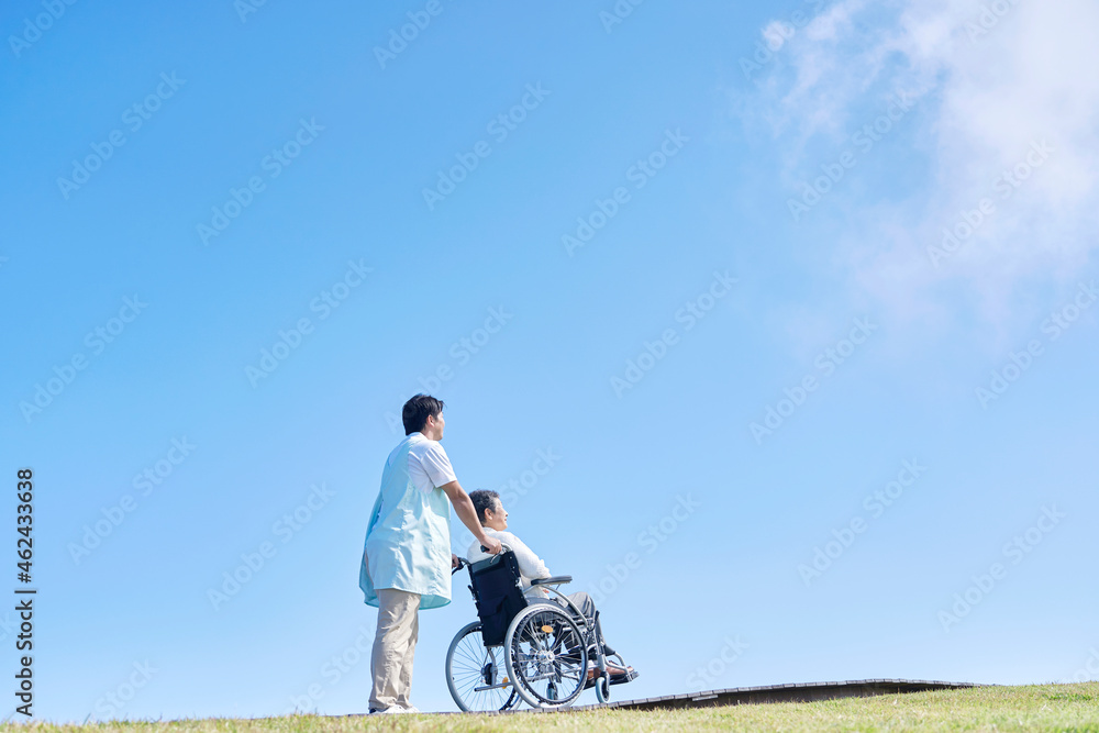 介護士と車椅子に乗る高齢者