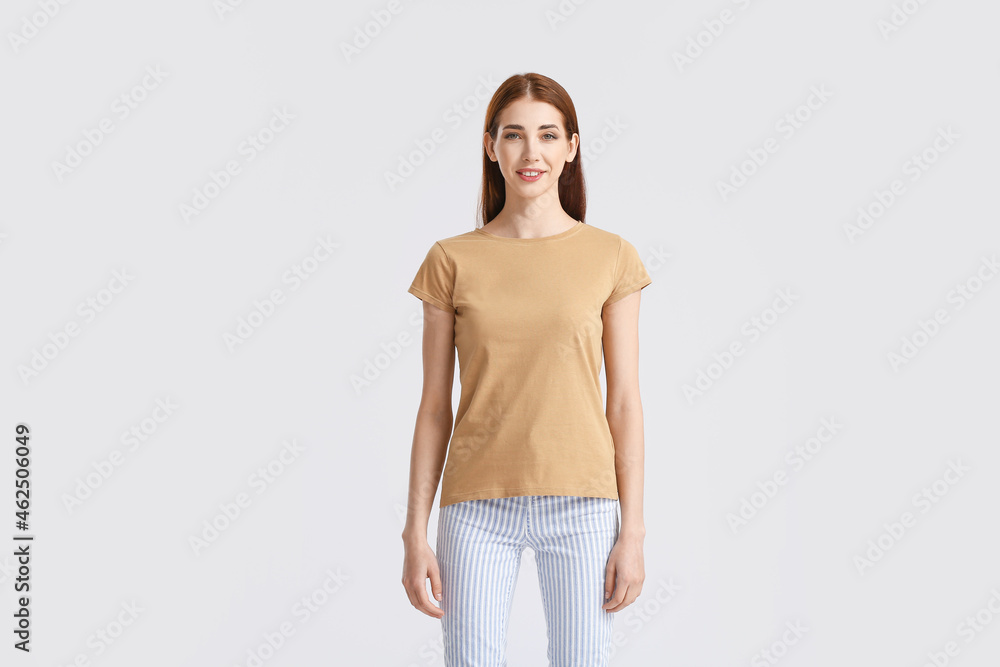 Young woman in modern t-shirt on light background