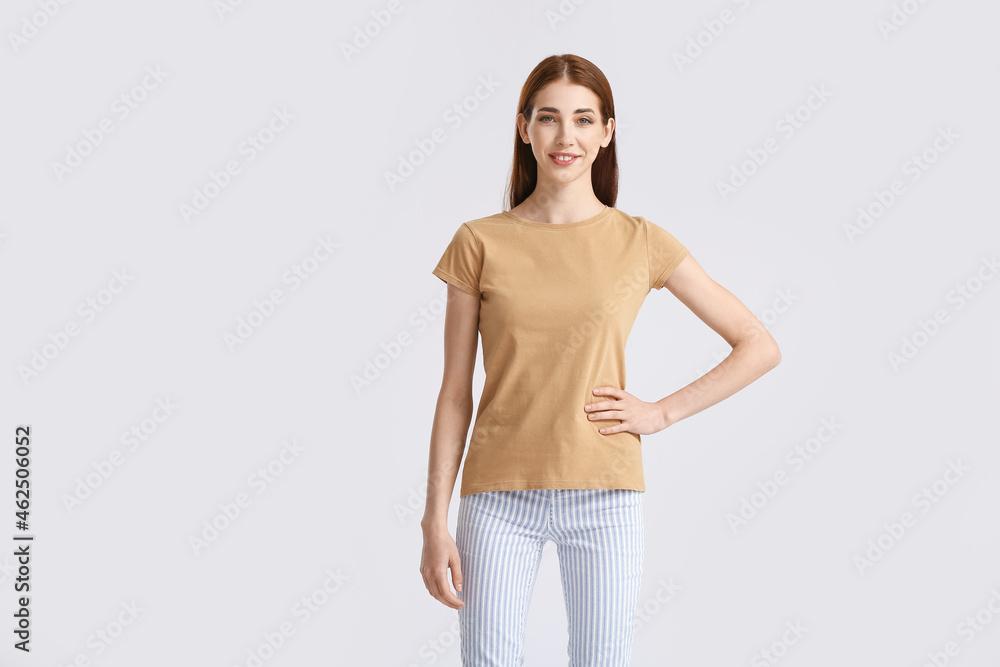 Young woman in modern t-shirt on light background