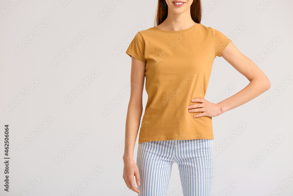 Young woman in modern t-shirt on light background