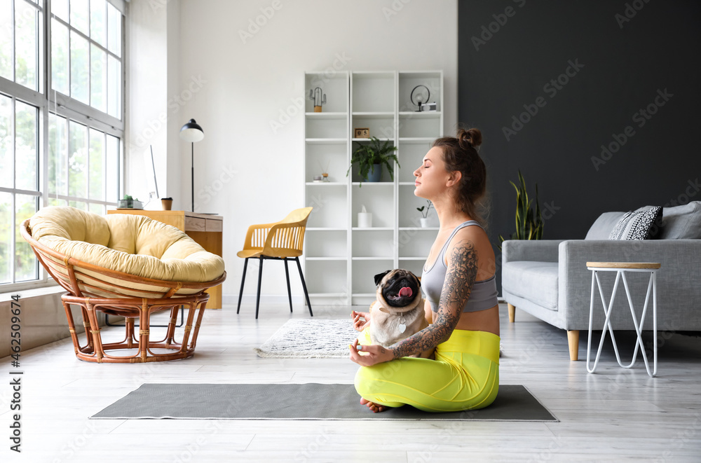 年轻女子带着可爱的哈巴狗在家冥想