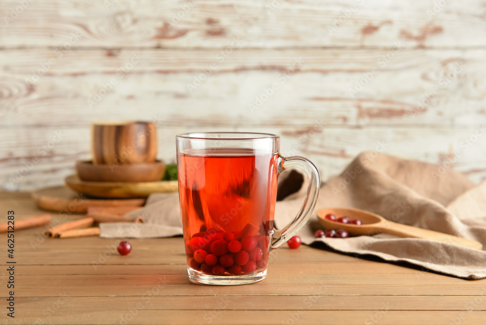 Cup of hot cranberry tea on wooden table