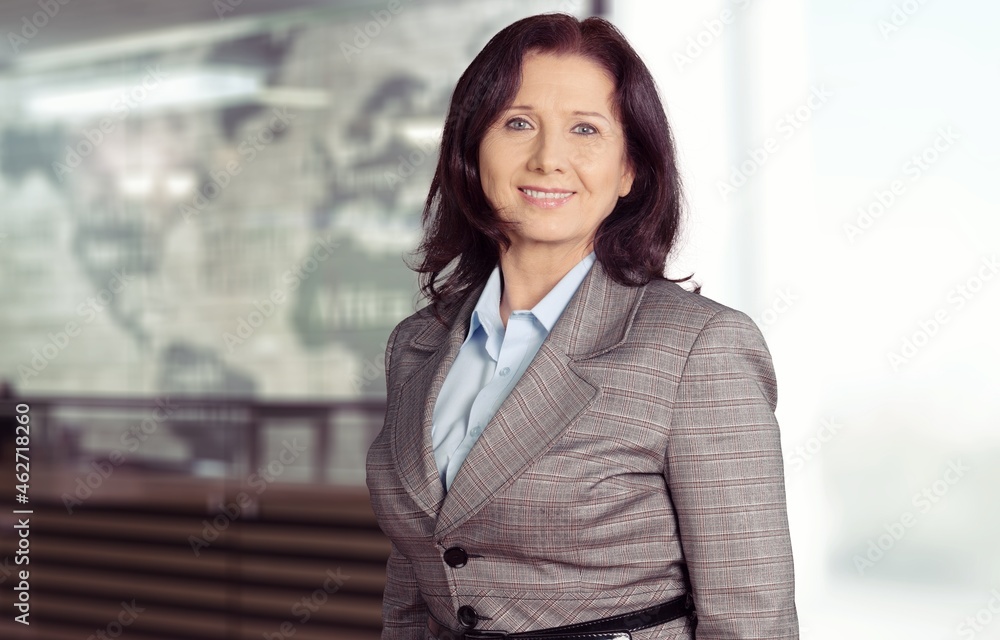 Happy attractive young businesswoman smiling while standing in a modern office