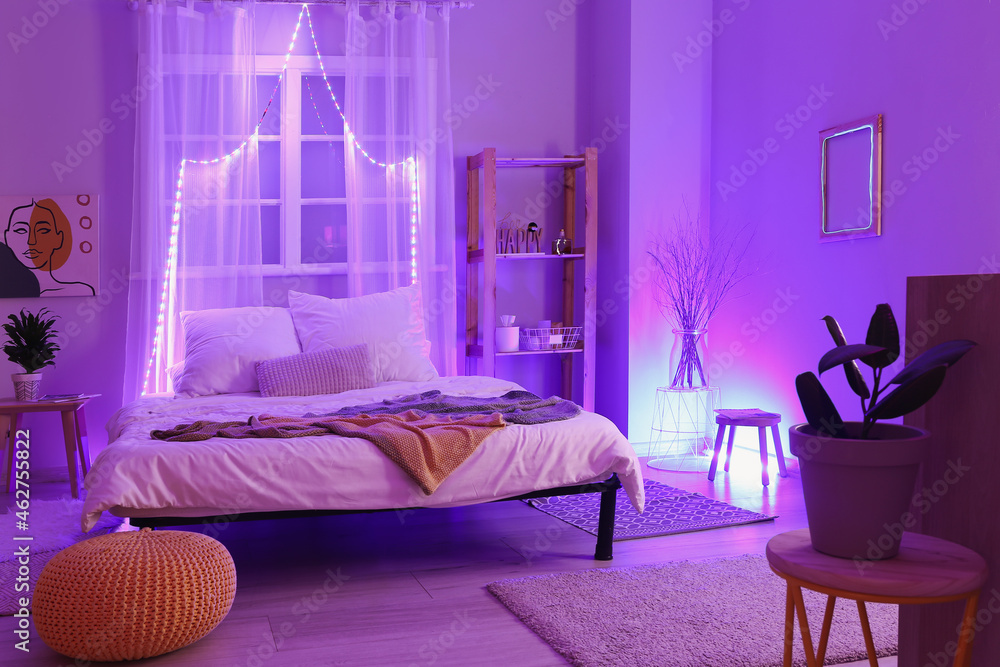 Interior of stylish bedroom with neon lighting