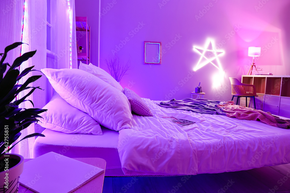 Interior of stylish bedroom with neon lighting