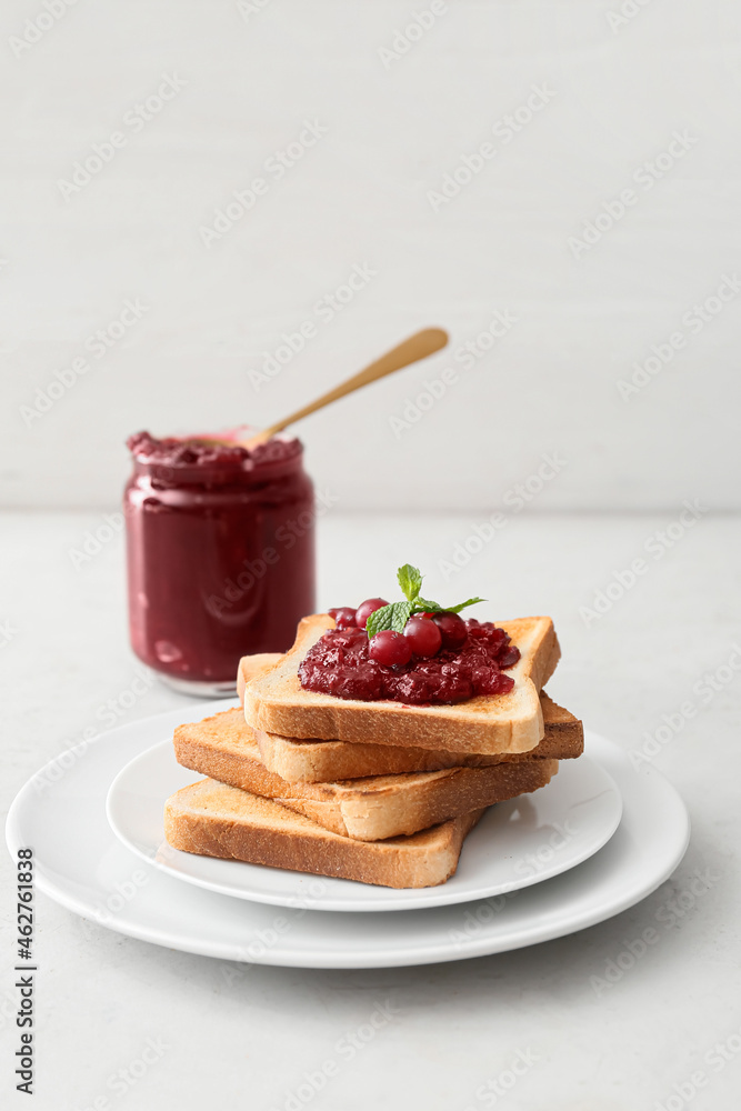 Plate with toasts and cranberry jam on table