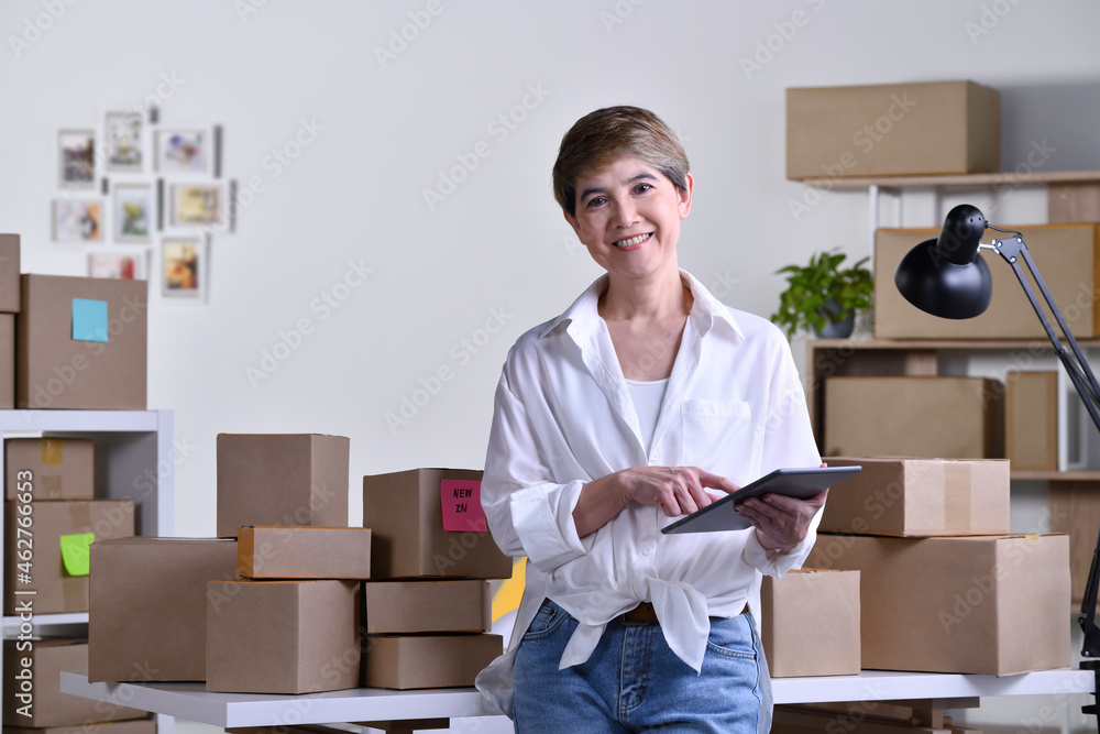 Middle aged Asian woman entrepreneur, Business owner checking address and delivery detail before shi