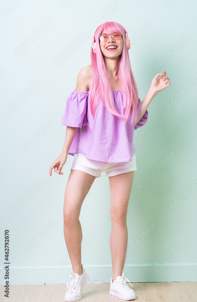 Young Asian woman with pink hair posing on green background