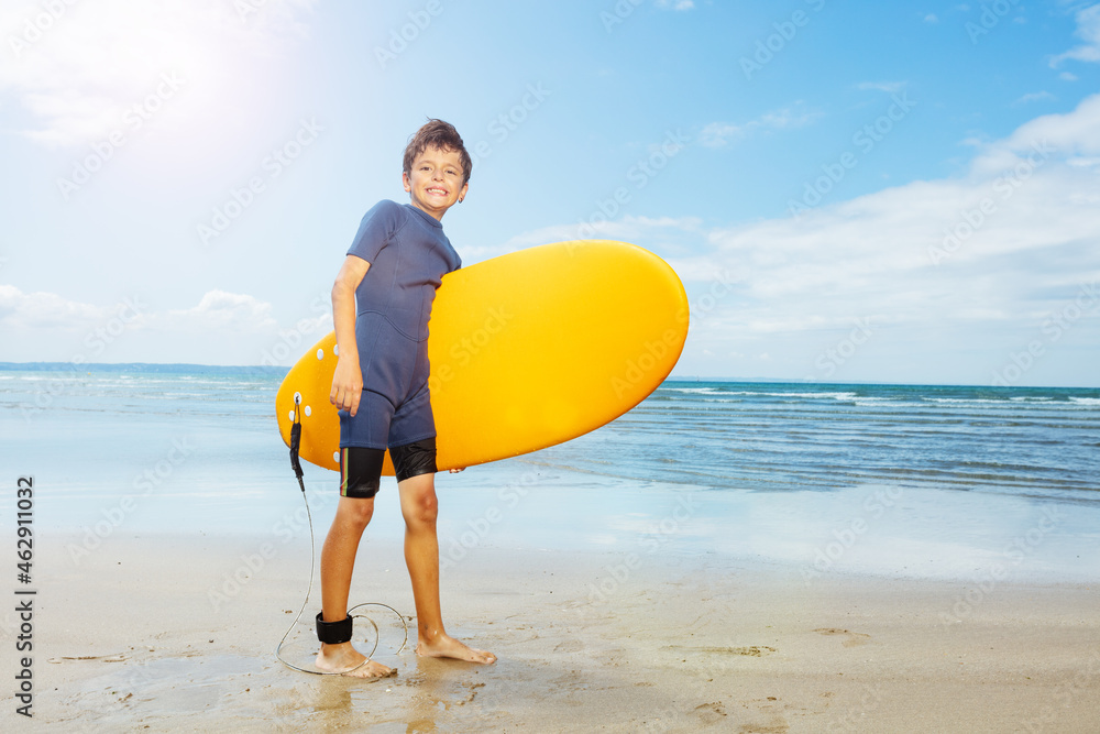 Boy walk with surfboard on the sand sea beach