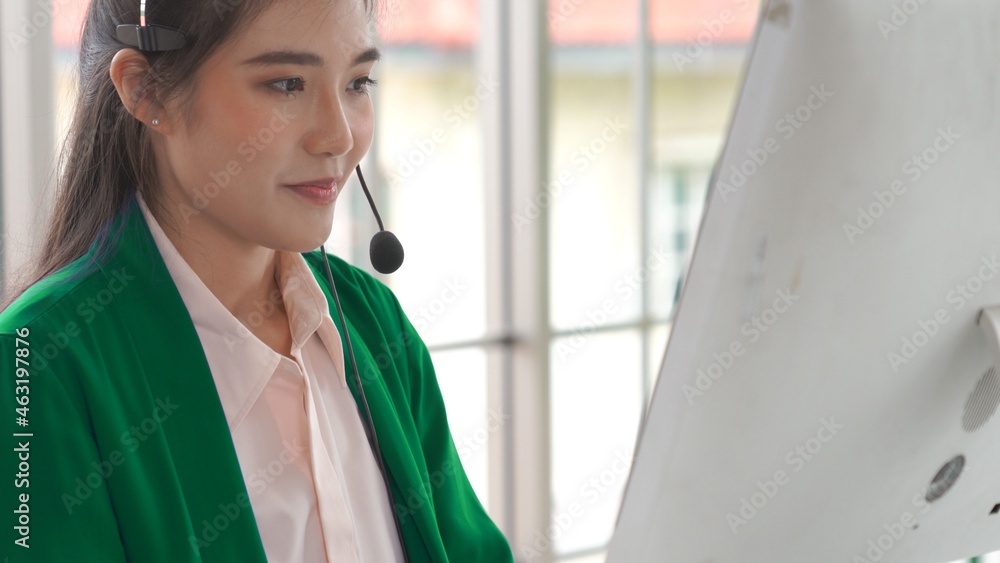 Businesswoman wearing headset working actively in office . Call center, telemarketing, customer supp