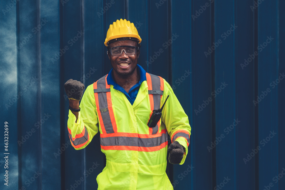 Young African American male worker at overseas shipping container yard . Logistics supply chain mana