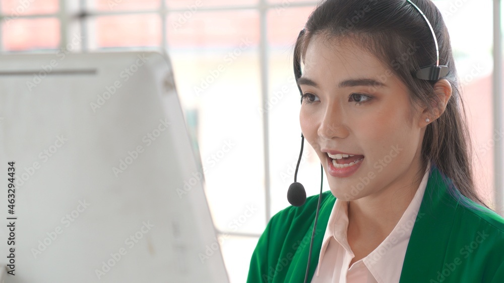 Businesswoman wearing headset working actively in office . Call center, telemarketing, customer supp