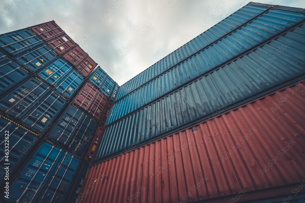 Cargo container for overseas shipping on high stack look up from ground . Logistics supply chain man