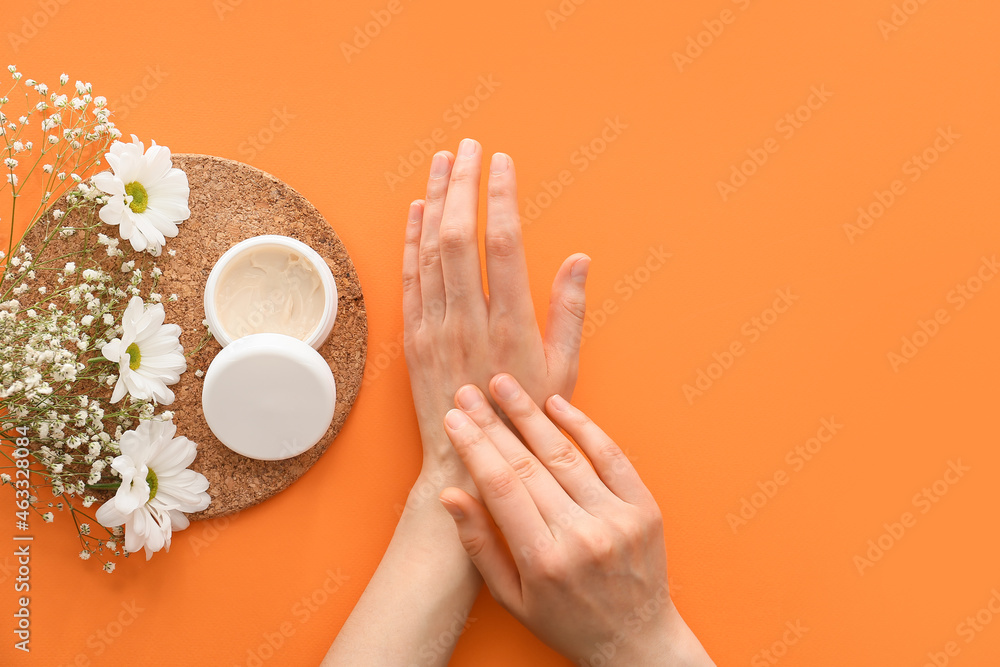 Woman with hand cream on color background