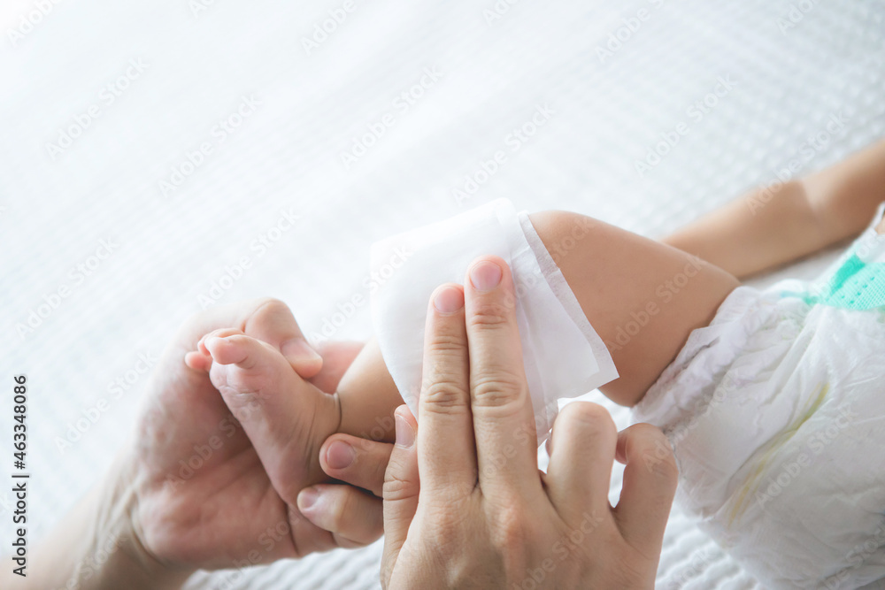 close up cleaning  leg and body of infant baby  by a soft wet tissue