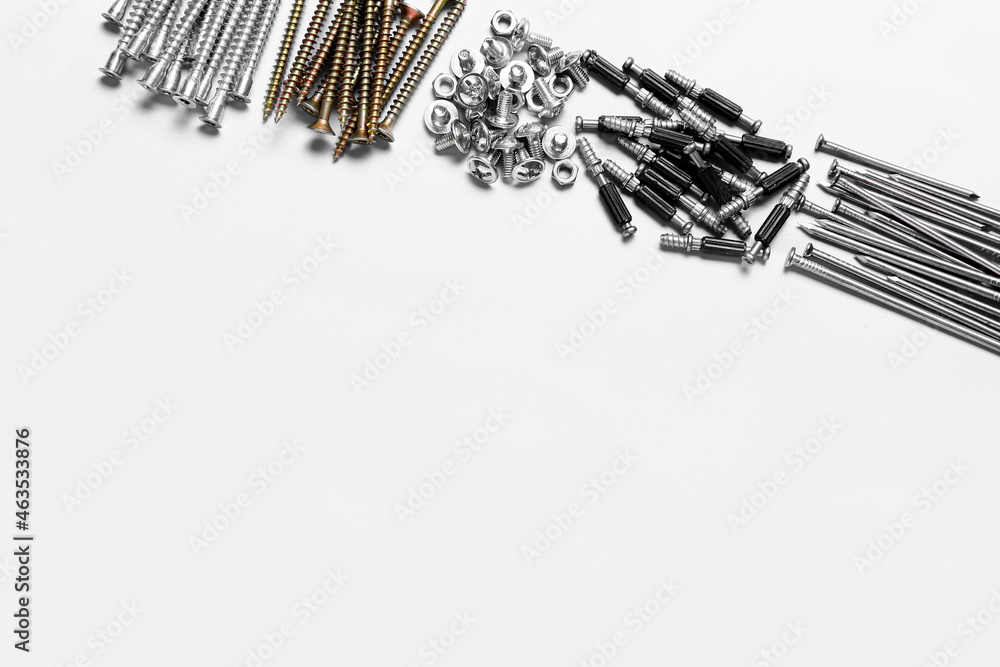 Piles of bolts screws and nails on white background, closeup