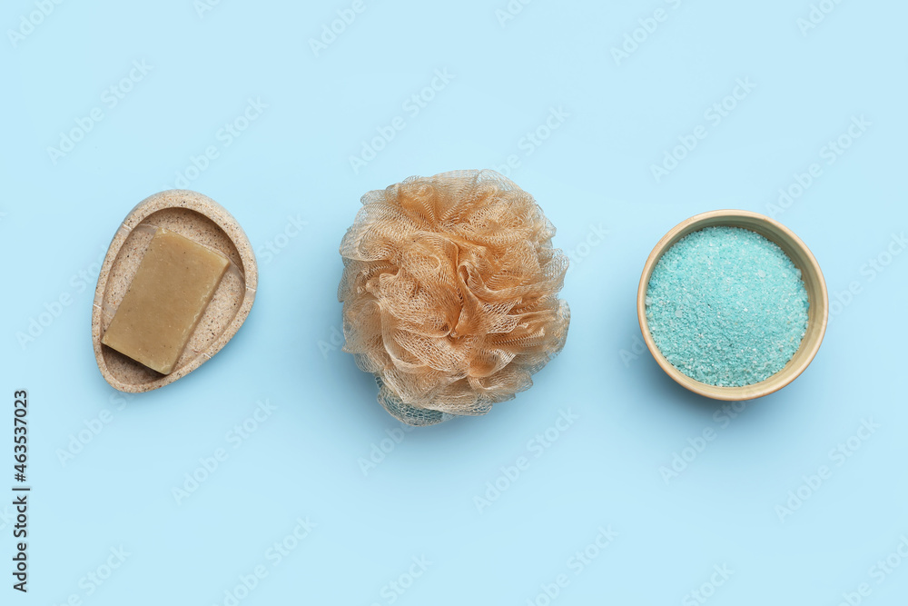 Soap, salt and bath sponge on color background