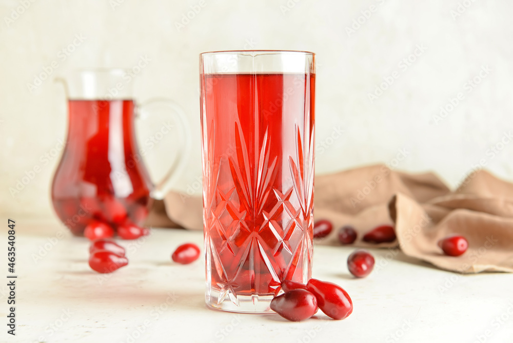 Glass of healthy dogwood berry drink on light background