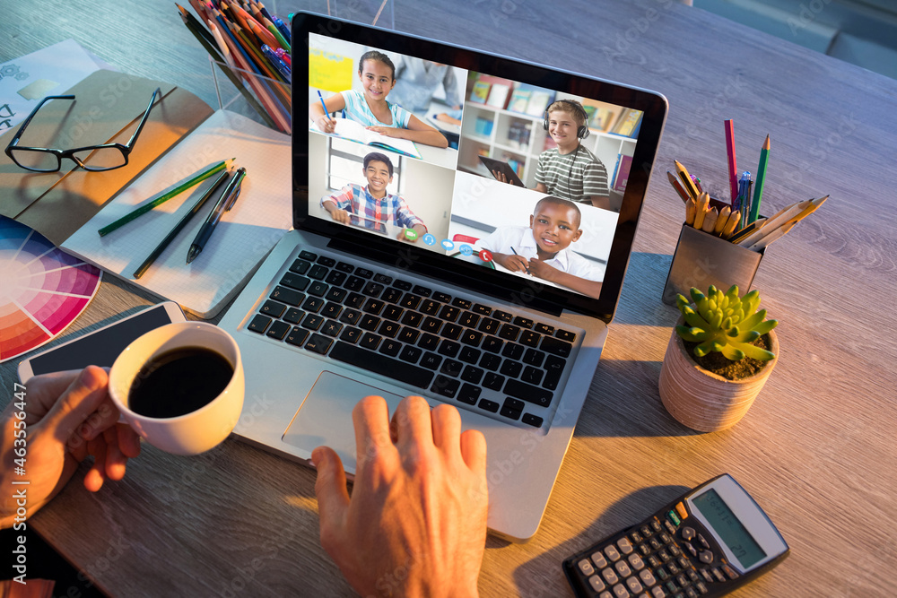 Hands of man using laptop for video call, with smiling diverse elementary school pupils on screen