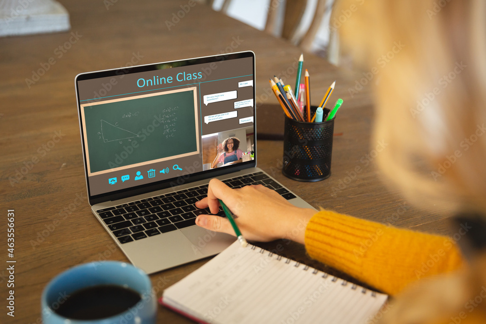 Caucasian woman using laptop for video call, with smiling female teacher on screen