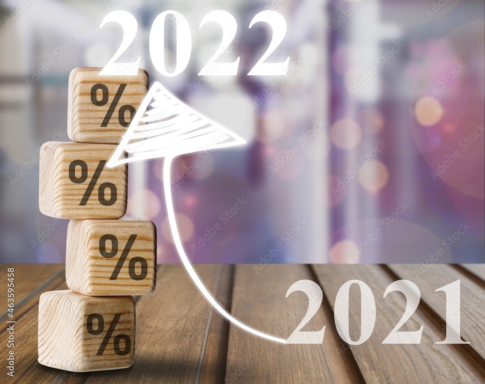 Shining rise up arrow on wooden blocks chart steps with percentage icons from year 2021 to 2022 on d