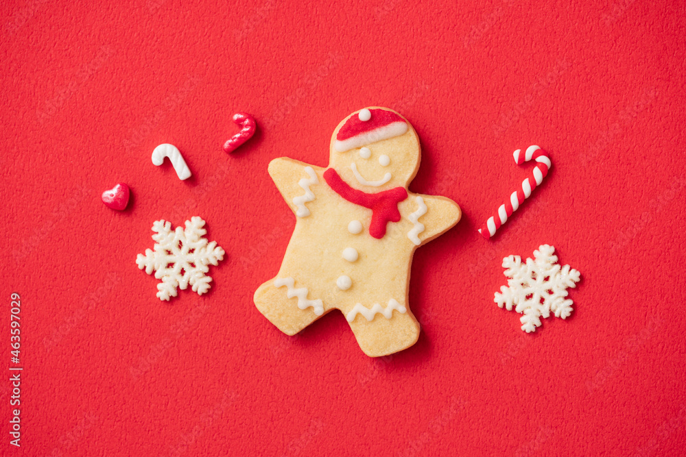 Decorated Christmas gingerbread cookies on red table background.