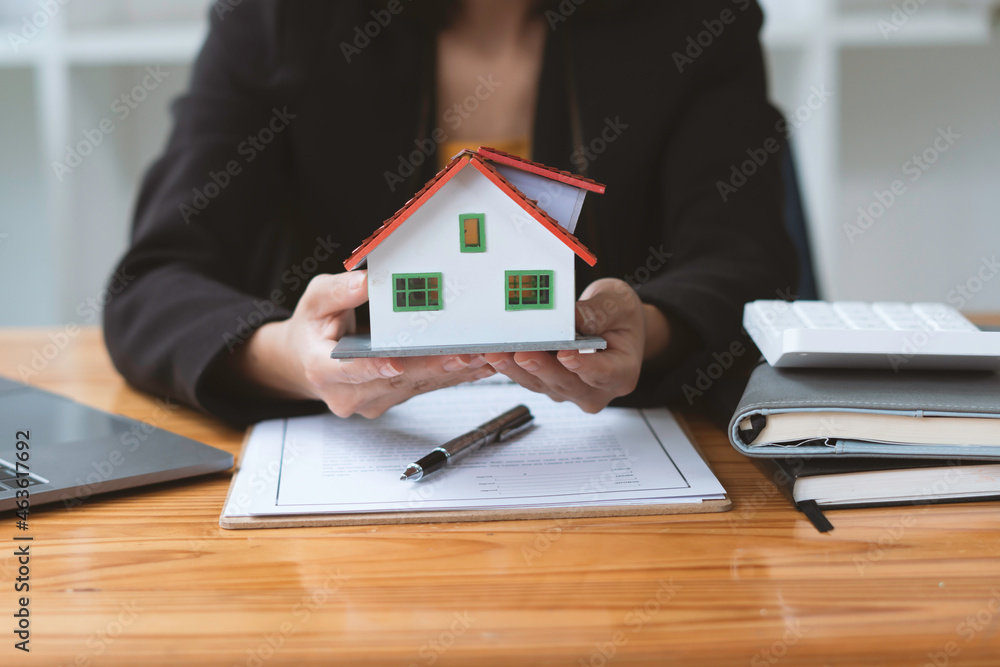 Buying a Home or Insurance, an insurance agent explains the lease agreement to a client before makin