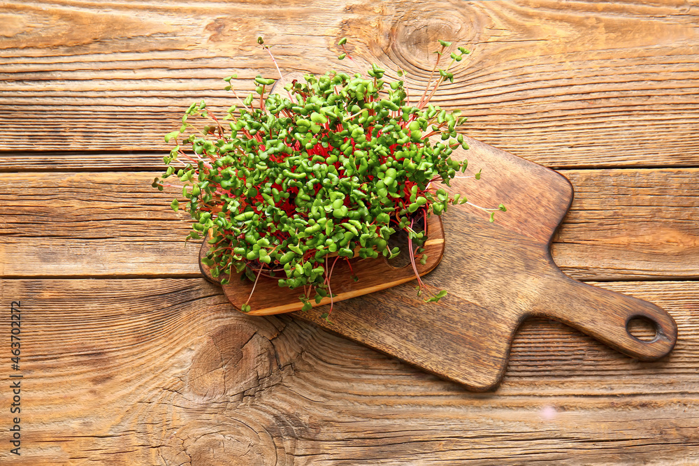 Boards with fresh microgreen on wooden background