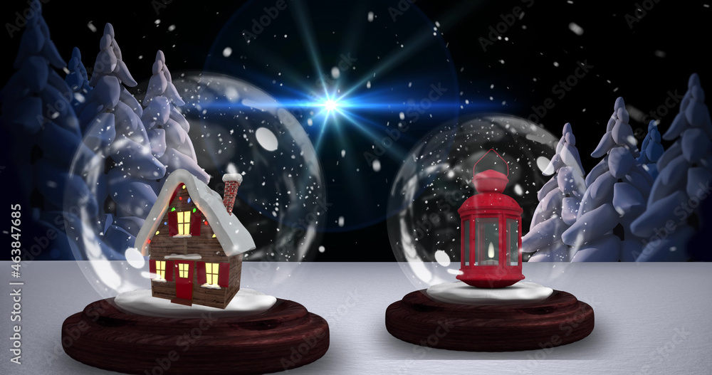 Image of two snow globes with house and christmas lantern with snow falling in winter scenery