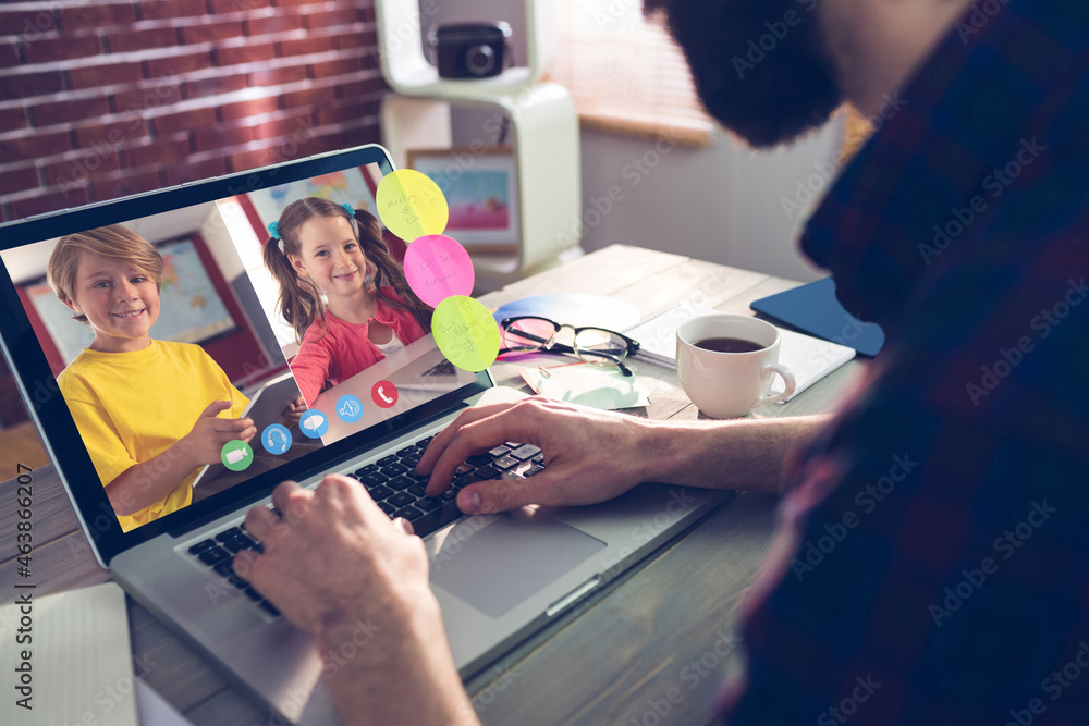 Caucasian man using laptop for video call, with smiling caucasian elementary school pupils on screen