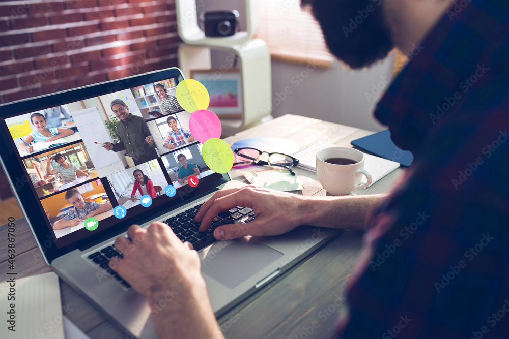 Caucasian man using laptop for video call, with smiling diverse elementary school pupils on screen