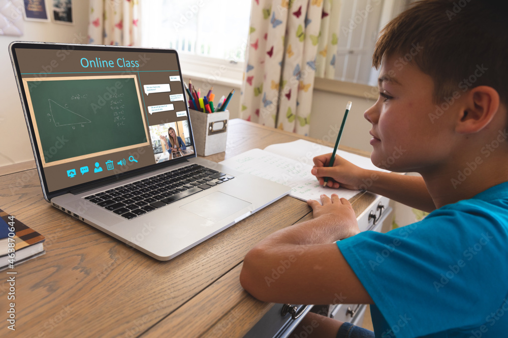 Caucasian boy using laptop for video call, with smiling female teacher on screen