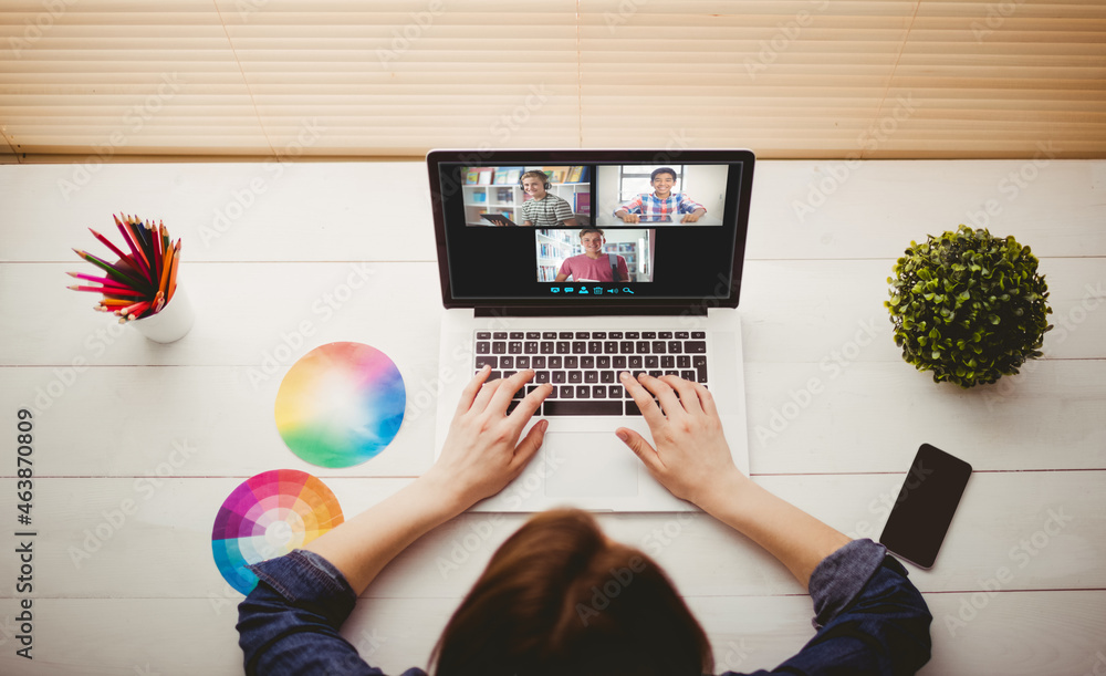 Caucasian woman using laptop for video call, with smiling diverse high school pupils on screen